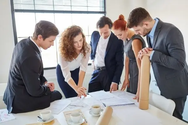 Team gathered around a table looking at documentation