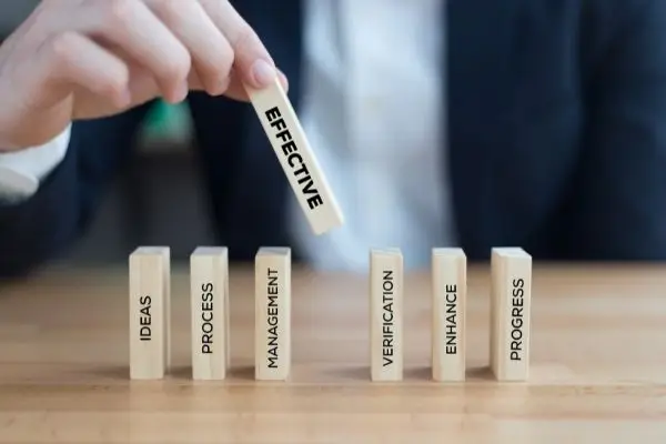 Man holding domino with effectiveness on it and inserting it into his process dominos