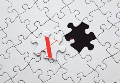 Red X on white puzzle pieces