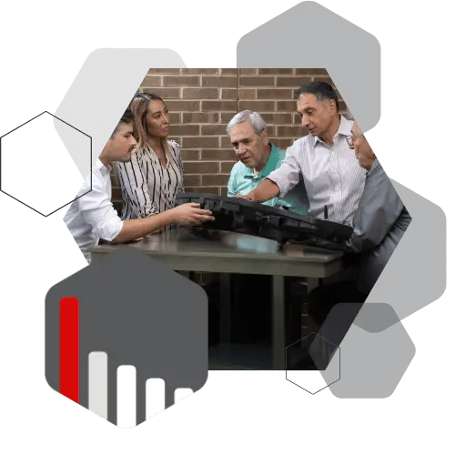 Shainin team members gathered around a table examining parts