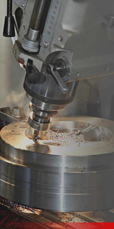A metallic part being drilled by a machine